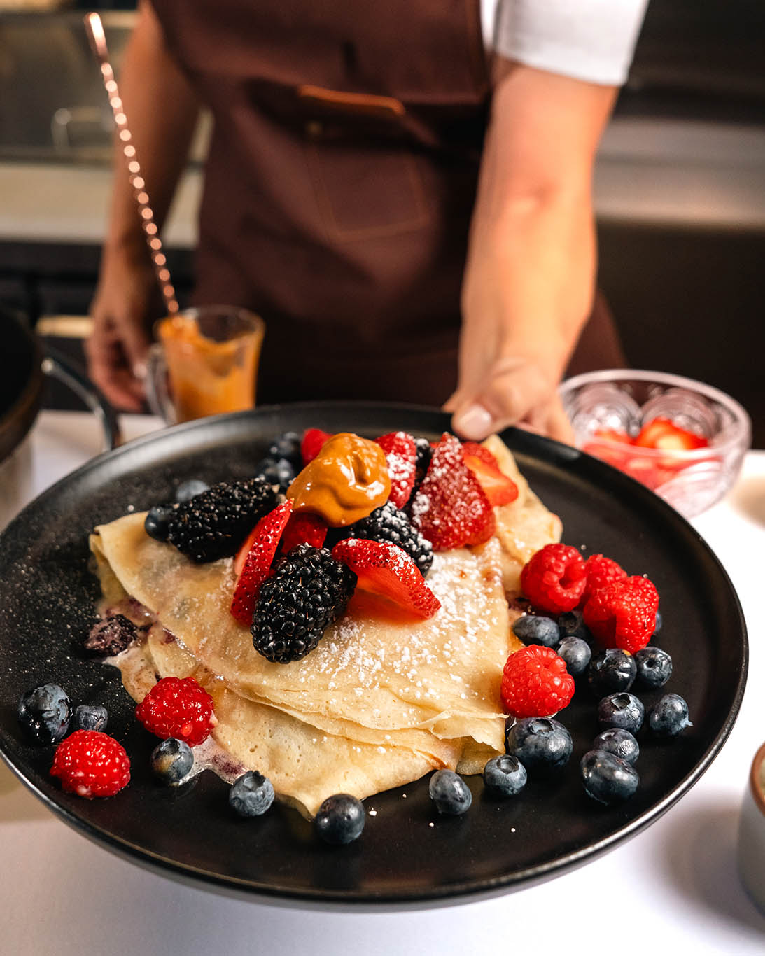 being served plated berry crepe